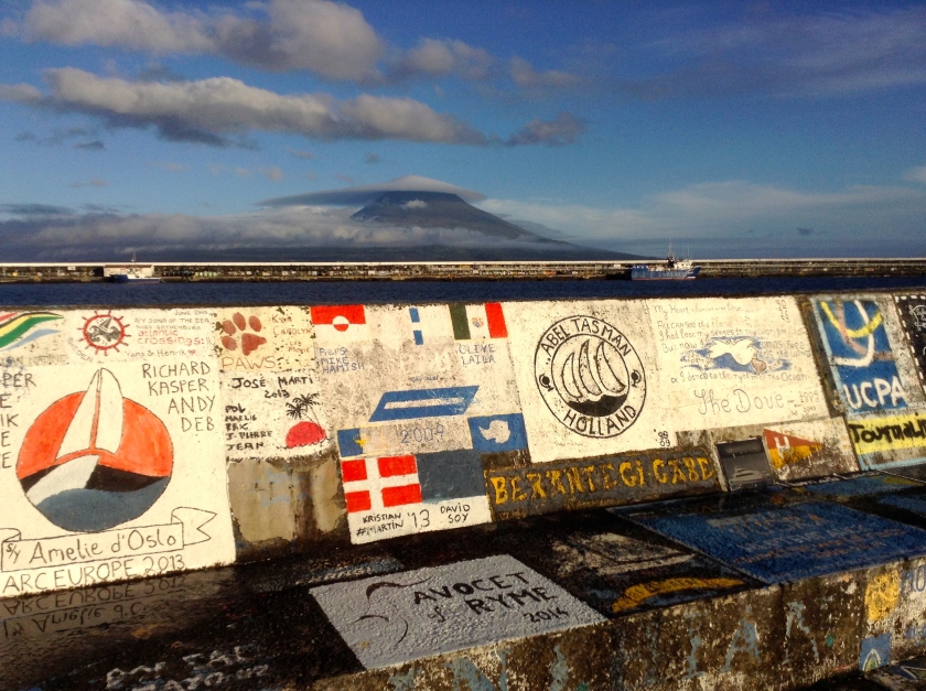 Graffiti covered breakwater at Horta Marina. In the background is Mt. Pico on neighbouring Pico Island capped with an unusual lenticular cloud.